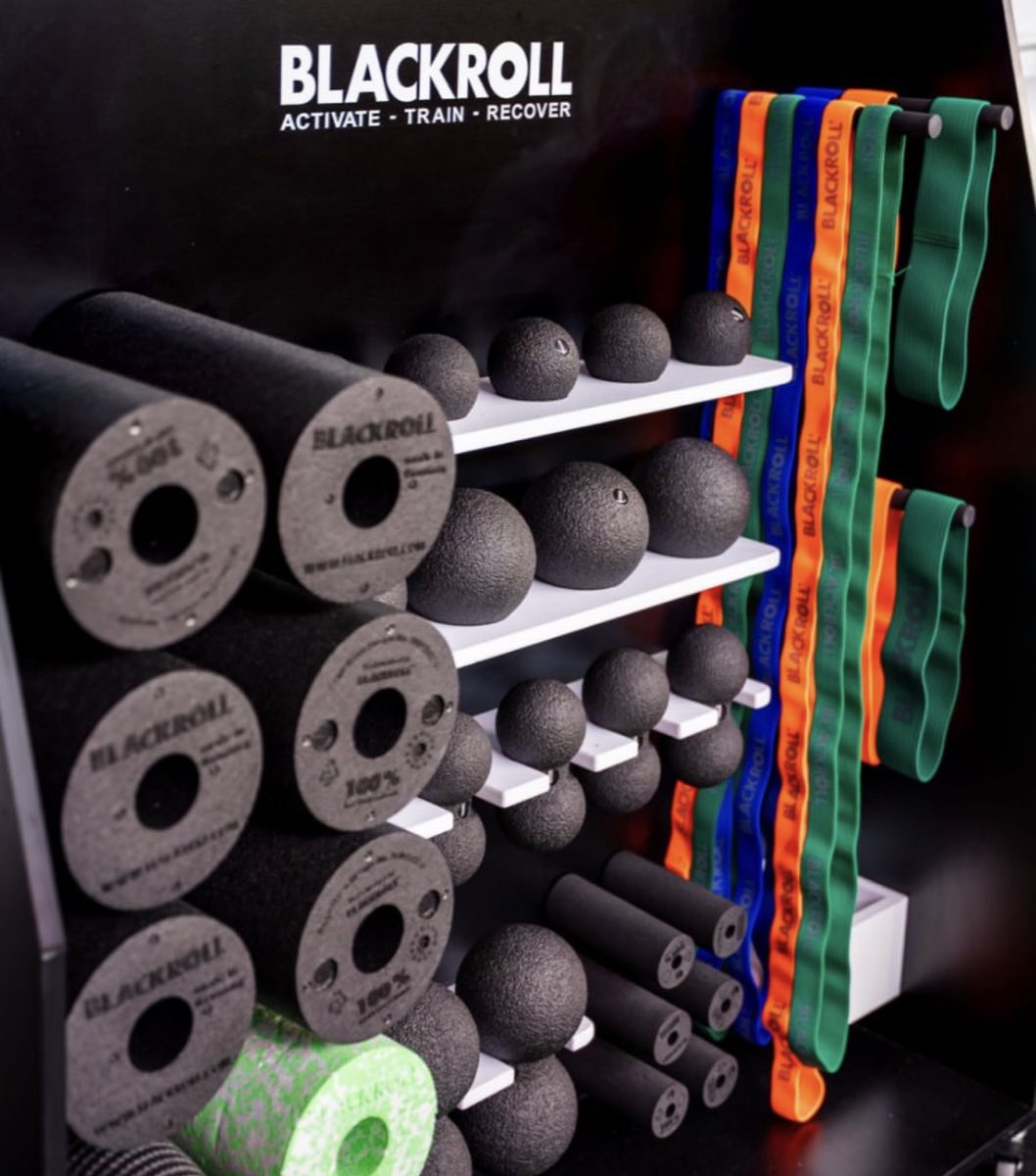 Foam rollers, massage balls and resistance bands racked on the recovery wall