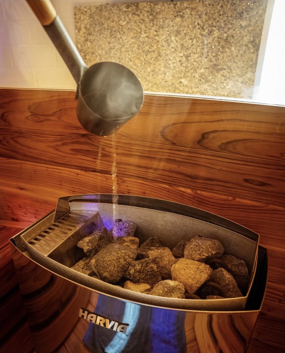 Water poured from a ladle onto hot sauna rocks