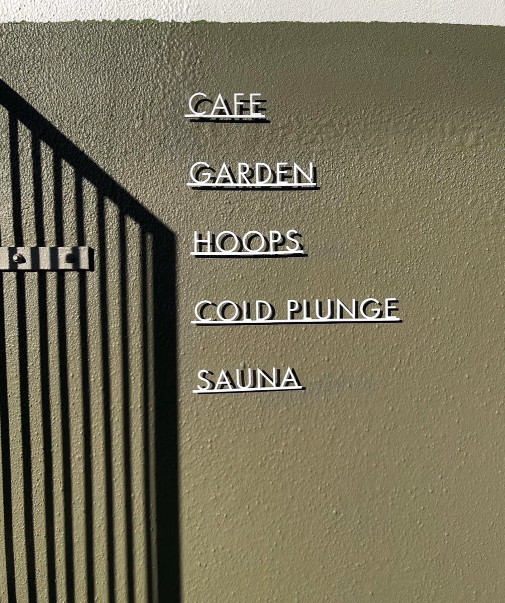 Wall signage at Ark reading cafe, garden, hoops, cold plunge, sauna